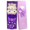 Bouquet de fleurs artificielles composé de roses violettes et de petits ours en peluche dans une boîte cadeau violette.