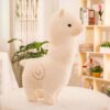Peluche de lama blanc doux avec un motif en spirale rouge sur son dos. Il est placé sur une table blanche dans un intérieur lumineux.