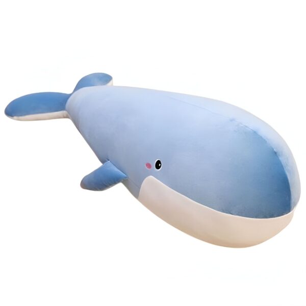 Une grande peluche bleue en forme de baleine avec un sourire et des joues roses.