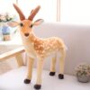 grande-peluche-cerf-jouet-peluche-animal-realiste-pour-enfant-decoration-1a-6 Une peluche de cerf tacheté marron et blanc debout sur un canapé blanc.