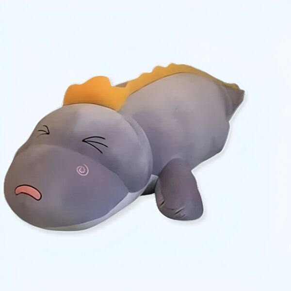 Peluche gris en forme de dinosaure avec des yeux fermés et une crête jaune.