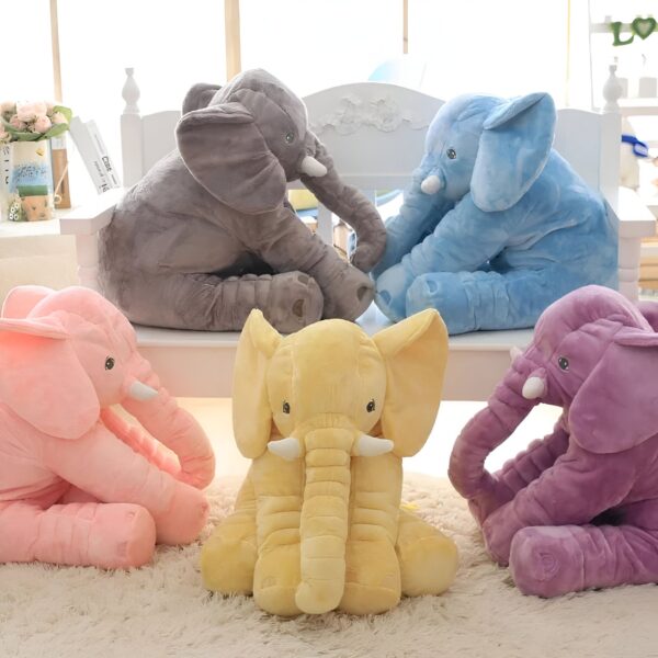Cinq éléphants en peluche de différentes couleurs : gris, bleu, rose, jaune et violet, assis sur un banc blanc.