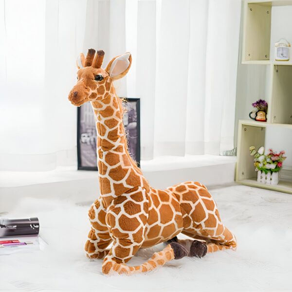 Une grande peluche de girafe en position assise sur un tapis blanc.