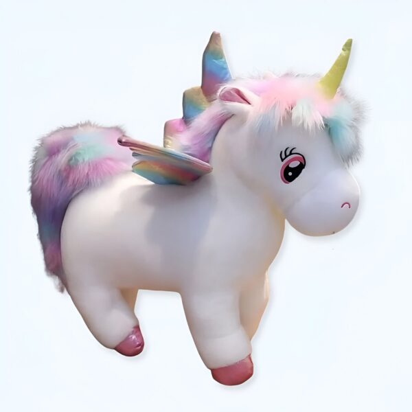 Une peluche de licorne blanche avec une crinière arc-en-ciel, une queue arc-en-ciel et des ailes arc-en-ciel.
