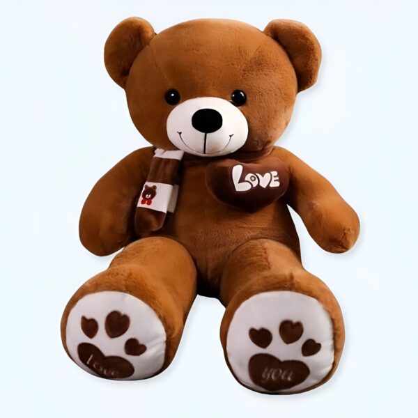 Un grand ours en peluche brun portant un foulard et un cœur avec l'inscription "Love" sur la poitrine. Les pattes de l'ours ont des empreintes de pattes avec l'inscription "Love you".
