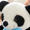 Gros plan sur la tête d'une peluche panda avec un nœud bleu à pois blancs.