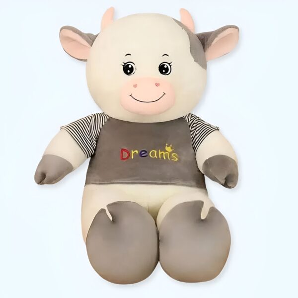 grande-peluche-vache-blanche-et-grise-doudou-calin-1a-3 Une peluche de vache blanche portant un t-shirt gris avec le mot "Dreams" écrit dessus.
