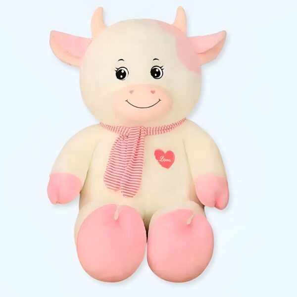 grande-peluche-vache-blanche-et-rose-70-cm-1a-2 Une peluche de vache blanche avec des taches roses, portant un foulard rose à rayures blanches et un cœur rouge brodé sur la poitrine.