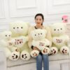 Une femme tenant trois ours en peluche avec un cœur "je t'aime" brodé sur la poitrine.