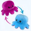 pack-de-2-peluches-pieuvre-reversible-bleu-et-rose-jouet-doux-et-tendre-1a-1 Deux poulpes en peluche, l'un rose avec un visage triste et l'autre bleu avec un visage heureux, se font face.