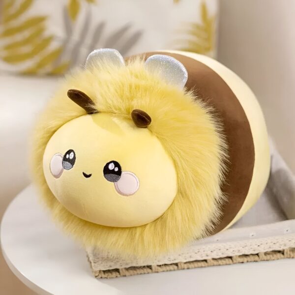Peluche abeille jaune avec des yeux noirs et une bouche souriante, assise sur un panier en osier blanc.