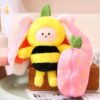 Peluche abeille en costume d'abeille, assis dans une fraise rose.