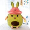 Peluche avocat souriant avec un chapeau de lapin rose.
