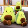 peluche-avocat-mignon-pour-fille-7a-1 Trois peluches en forme d'avocat avec des visages souriants assis sur un canapé.