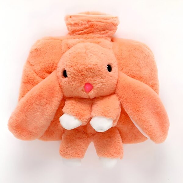 Bouillotte en forme de lapin rose en peluche.