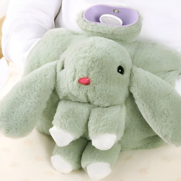 Une bouillotte en forme de lapin vert en peluche avec des oreilles longues et une bouche rose.