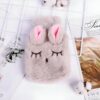 Bouillotte en peluche en forme de lapin avec des oreilles roses et des yeux brodés.
