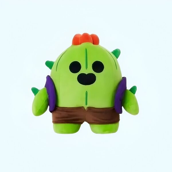 Une peluche verte représentant le personnage de jeu vidéo "Cactus" de Brawl Stars. Il porte un short brun et a un visage souriant.