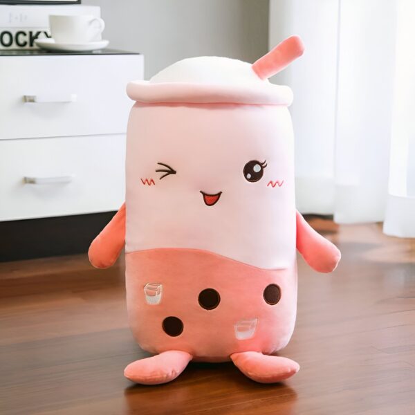 Une peluche en forme de tasse de bubble tea souriante avec une paille.
