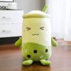 Une peluche en forme de boisson au thé à bulles avec un visage souriant et des perles de tapioca vertes.