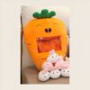Un coussin en forme de carotte souriante avec une poche transparente remplie de petits lapins en peluche.