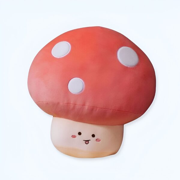 Coussin en forme de champignon rouge à pois blancs avec un visage souriant.