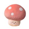 Oreiller en forme de champignon rose avec des points blancs et un visage souriant.