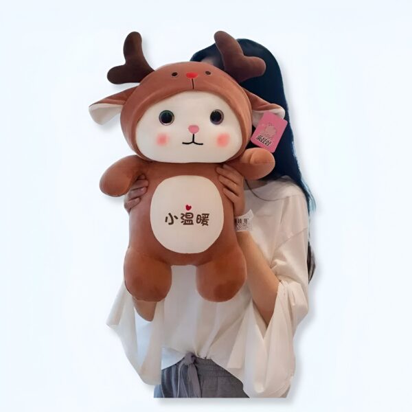 Une jeune femme tient une peluche marron en forme de renne avec des grands yeux et un petit cœur sur la poitrine. La peluche est écrit "小鹿".