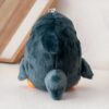 Peluche de pingouin gris vu de derrière, avec un porte-clés en métal.