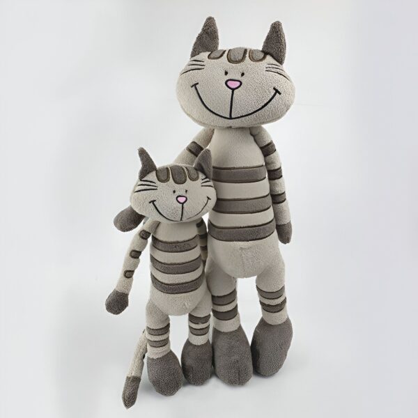 Deux peluches en forme de chat rayées de gris et de beige, debout l'une à côté de l'autre. Le plus grand chat a un sourire plus large.