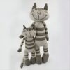 Deux chats en peluche rayés gris et blancs, l'un plus grand que l'autre, sourient.