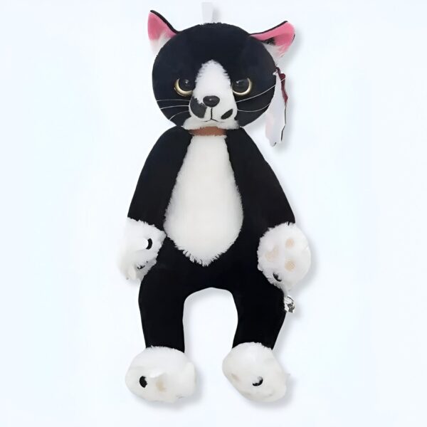 Peluche de chat noir et blanc avec des pattes blanches et des yeux jaunes.