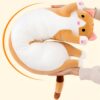 Oreiller en forme de chat en peluche blanc et orange avec des pattes et une queue roses.