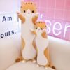 Deux coussins en forme de chat, un grand et un petit, sont posés sur un canapé blanc.
