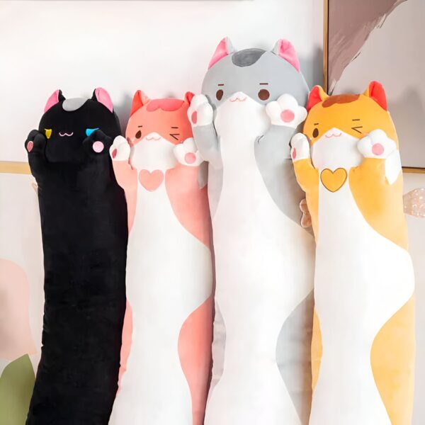 Quatre oreillers en forme de chat, noirs, roses, gris et orange, disposés côte à côte.
