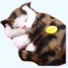 Un chat en peluche brun, noir et blanc dormant sur le côté, avec une étiquette "Prestige" jaune.