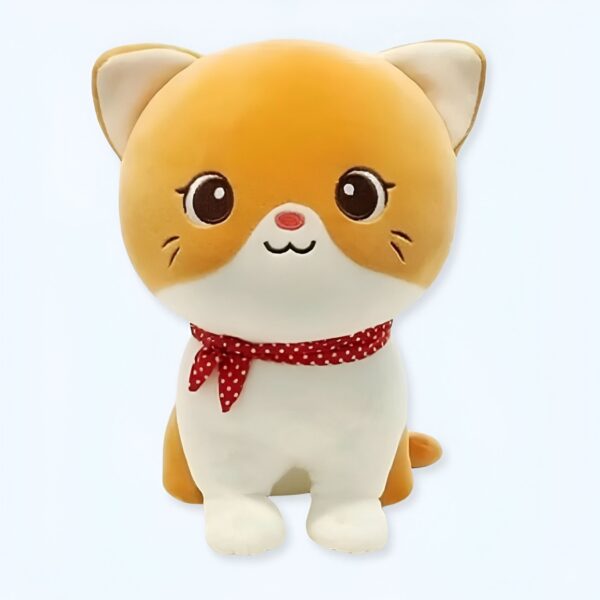 Une peluche de chat orange avec un foulard rouge à pois blancs.