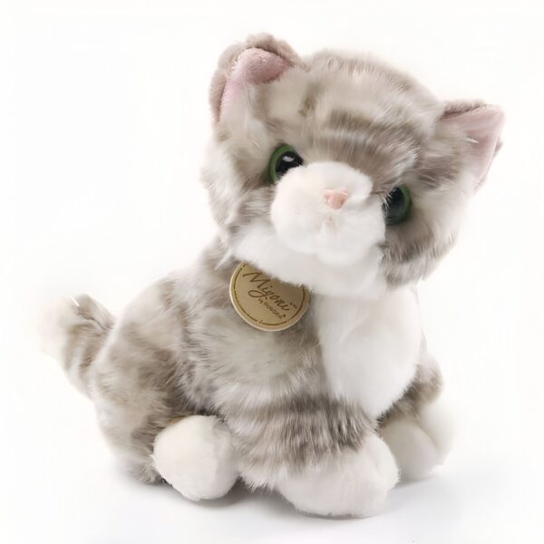 peluche-chaton-tout-doux-3a-2 Une peluche de chat gris et blanc avec des yeux verts, portant une étiquette de la marque "Myoni" sur la poitrine.
