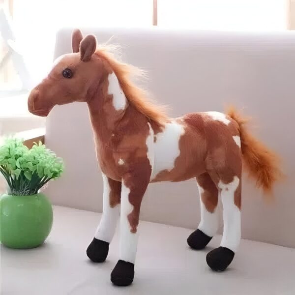 Une peluche de cheval marron et blanc avec une crinière et une queue brunes.