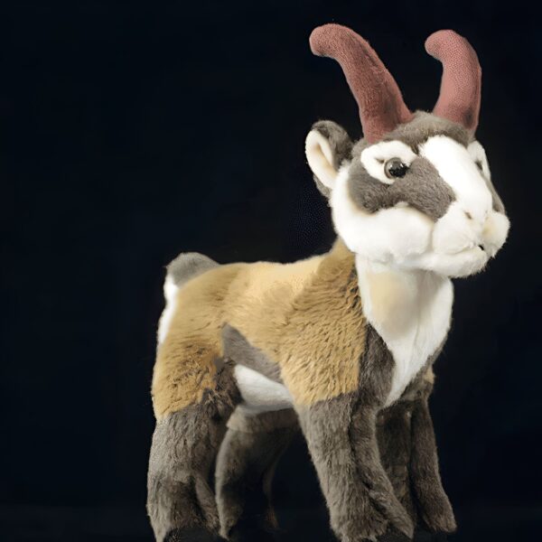 Une peluche de chamois de montagne avec des cornes courtes et une fourrure brune, blanche et dorée.