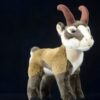 Une peluche de chamois avec des cornes brunes, un corps brun et blanc et des yeux noirs.