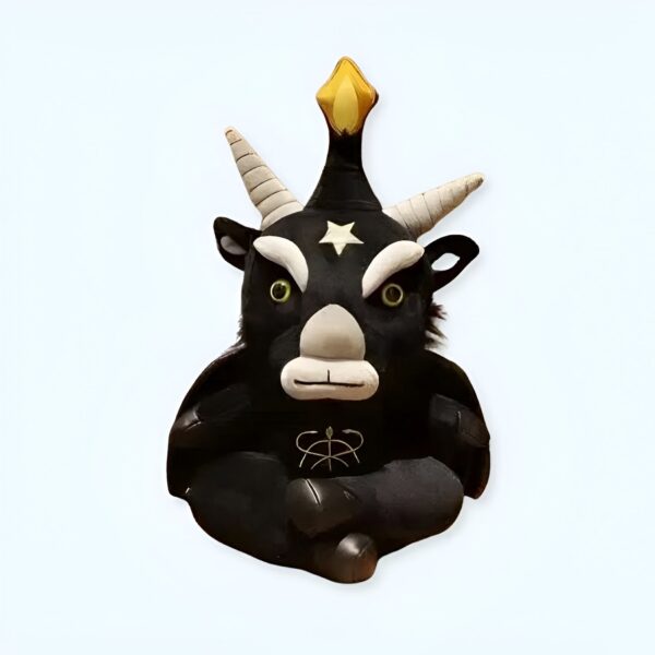 Une peluche noire en forme de démon avec des cornes et une étoile sur la tête, assis en tailleur.