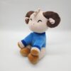 Une peluche mignonne en forme de mouton avec des cornes brunes, portant un pull bleu.