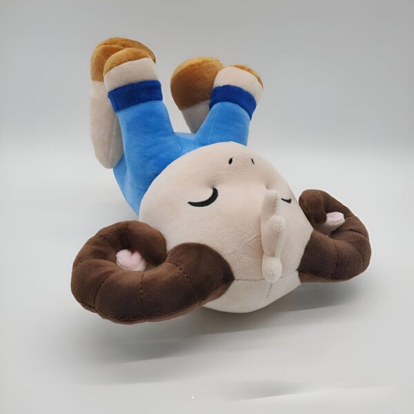 Peluche de mouton mignon portant un pantalon bleu, allongé sur le dos.