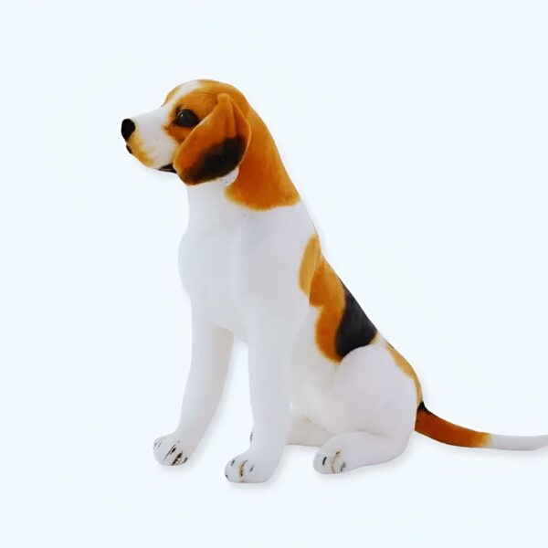 Un chien en peluche blanc, brun et noir assis sur un fond blanc.