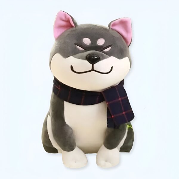 Peluche de chien gris portant un foulard à carreaux rouges et noirs.