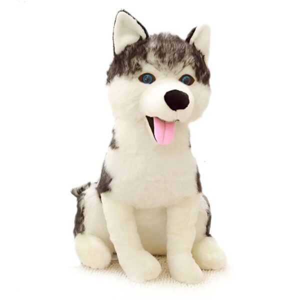 Peluche de chien husky assis avec la langue qui pend, les yeux bleus et le pelage blanc et gris.