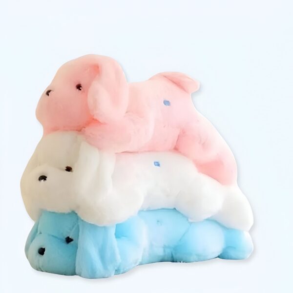 Trois peluches en forme de chiots, empilées l'une sur l'autre, en rose, blanc et bleu.