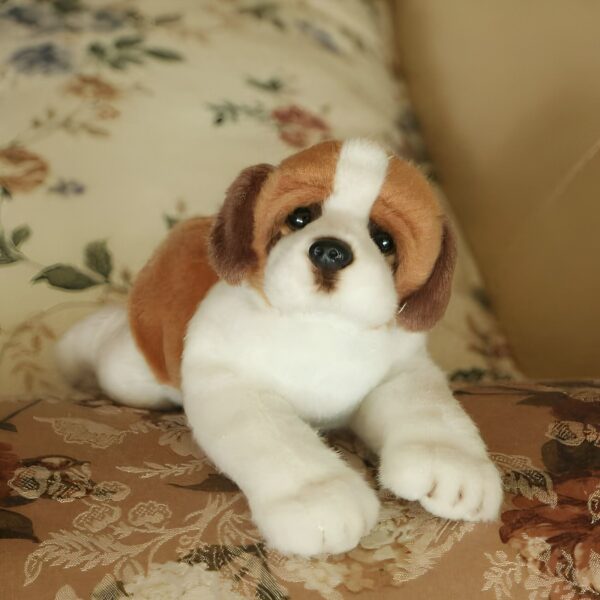 peluche-chien-peluche-realiste-ultra-mignon-4a-2 Un chien en peluche blanc et marron, allongé sur un canapé avec un motif floral.