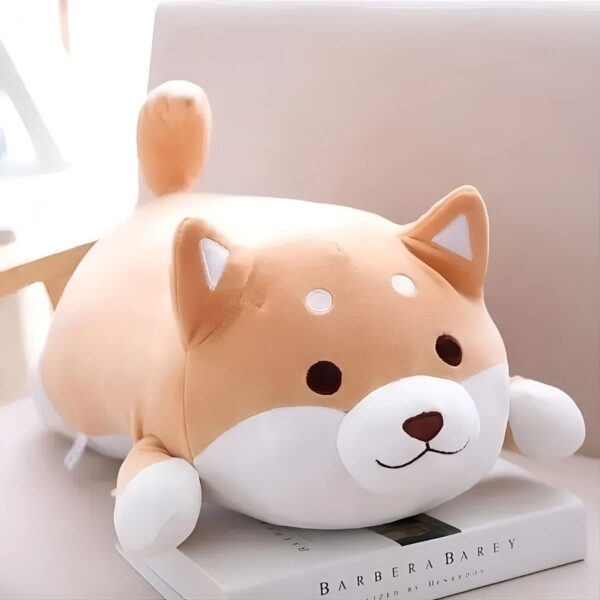 Une peluche de chien Shiba Inu allongé sur un livre.